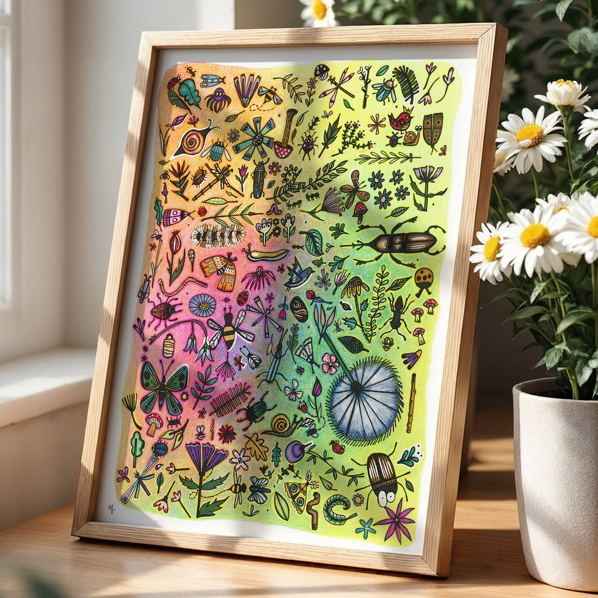 Framed colorful bugs and flowers print by Joy and Fury Art on a desk