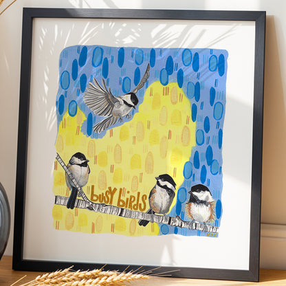 Framed Busy Birds chickadee print by Joy and Fury Art on a wooden surface