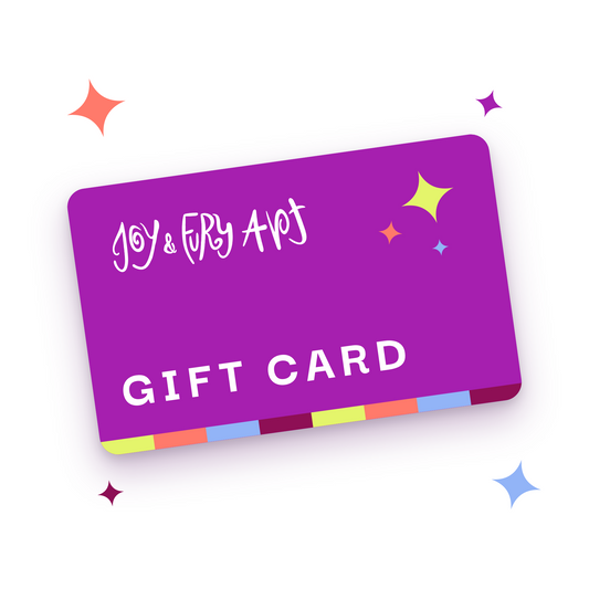 Purple Joy & Fury Art gift card tilted at an angle on a white background, with whimsical white logo lettering, a multicoloured strip along the bottom and colourful sparkles surrounding the card.